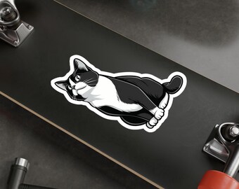May include: Black and white cartoon cat sticker on a skateboard. The cat is looking to the left and has a white patch on its chest.