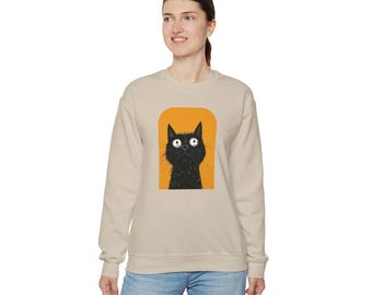 May include: A beige sweatshirt with a black cat illustration on the front. The cat is looking up with big eyes and is surrounded by a yellow oval.