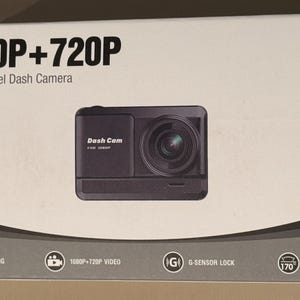 May include: A black dual channel dash camera with the text "1080P+720P Dual Channel Dash Camera" and "Dash Cam" on the front. The camera has a 170° wide angle lens and features loop recording, G-sensor lock, and 1080P+720P video.