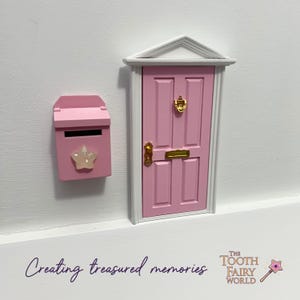 Peut inclure: Une porte de f&eacute;e en bois rose avec un heurtoir de porte en or et une bo&icirc;te aux lettres rose assortie avec une &eacute;toile. Le texte "Creating treasured memories" est &eacute;crit sous la porte et "The Tooth Fairy World" est &eacute;crit sous le texte.