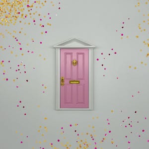 Peut inclure: Une porte miniature rose avec des accents dor&eacute;s et un cadre blanc sur un fond gris clair avec des paillettes dor&eacute;es et roses &eacute;parpill&eacute;es autour.