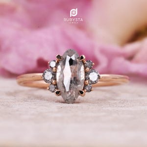 May include: A set of three ceramic mugs with a speckled, cream-colored glaze. Each mug features a different hand-painted floral design in shades of blue, green, and yellow. The mugs have a simple, modern shape.