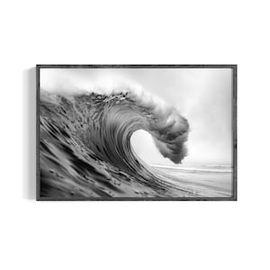 May include: Monochrome framed print of a breaking wave. The image captures the wave's curl and frothy crest as it crashes. The photograph highlights the dynamic movement and texture of the water, with a dark grey frame.
