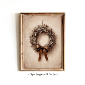 Puede incluir: Impresión enmarcada con una corona de hojas secas y una cinta marrón. La corona está centrada sobre un fondo beige dentro de un marco dorado. El texto "~ Springwell Arts ~" está en la parte inferior.
