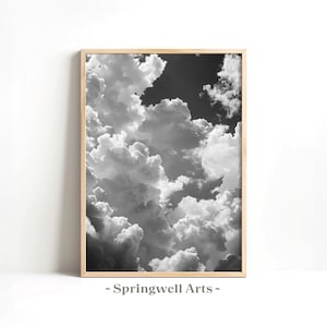 Könnte beinhalten: Schwarz-Weiß-Druck in einem Rahmen mit einer dramatischen Wolkenlandschaft. Das Bild zeigt eine dichte Anordnung von flauschigen, weißen Wolken vor einem dunklen, stimmungsvollen Himmel. Das Kunstwerk ist in einem hellfarbigen Holzrahmen eingefasst, mit dem Text "~ Springwell Arts ~" unten.