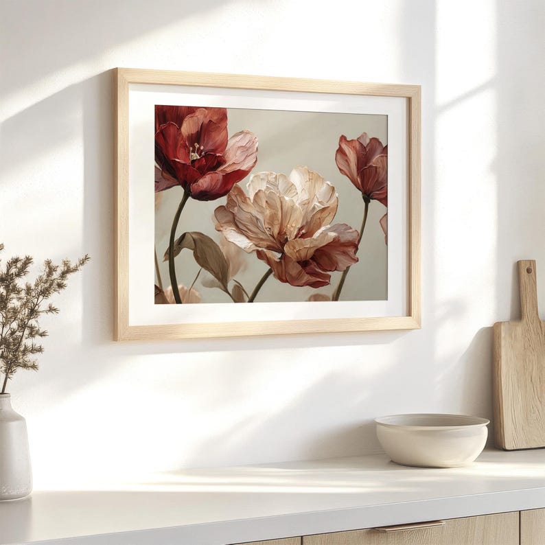 May include: A framed floral print featuring watercolor-style tulips in shades of red, pink, and cream. The artwork is set against a neutral background and framed in a light wood. The print is displayed on a white surface.