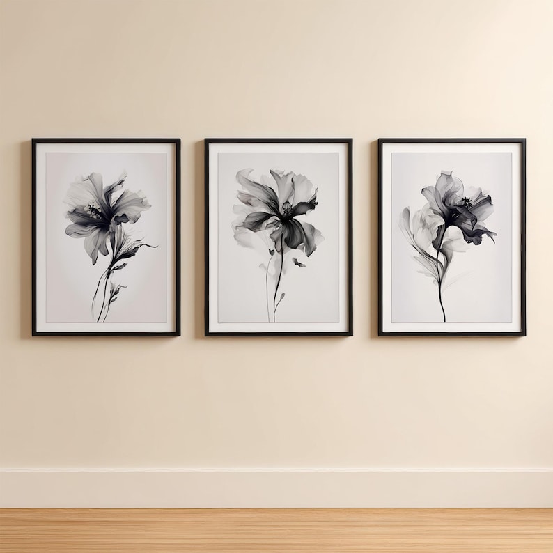 May include: Three framed floral art prints. Each print features a black and white image of a flower with delicate petals and stems. The prints are displayed in black frames and hung on a neutral-colored wall, creating a modern and elegant aesthetic.