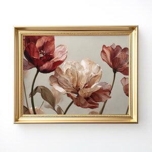 May include: A framed floral art print featuring a cluster of large, stylized flowers in shades of red, peach, and cream. The flowers are set against a neutral background, and the artwork is enclosed in a gold-colored frame.