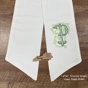 May include: White table runner with an embroidered emerald green letter "P" and fresh green vines. A wooden Kentucky-shaped embellishment is at the bottom. The text at the bottom reads: Letter: Emerald Green, Vines: Fresh Green.