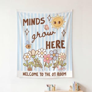 May include: A light blue and white striped wall tapestry with the words "Minds grow HERE" in brown lettering. The tapestry features a cartoon sun, bee, butterfly, and flowers. The text "WELCOME TO THE OT ROOM" is at the bottom.