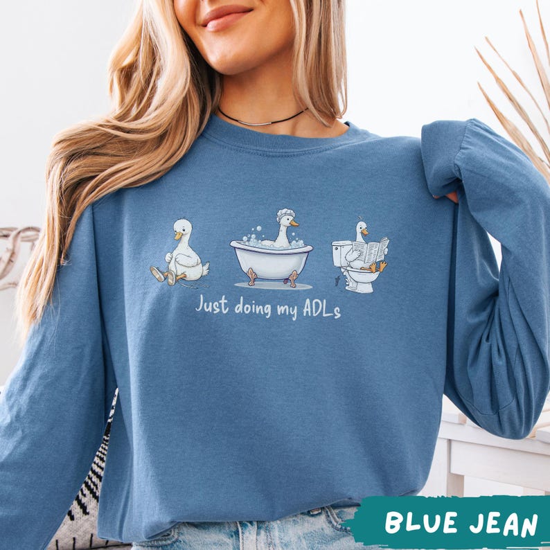 Op de afbeelding: Een witte keramische mok met een zwart handvat en de tekst "But First, Coffee" in een vetgedrukte, zwarte letter. De mok is gevuld met een donkere vloeistof, waarschijnlijk koffie, en staat op een lichtgekleurd oppervlak.