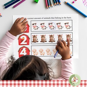 May include: A child is working on a farm animal counting worksheet. The worksheet has red barns with numbers and rows of farm animals. The child is using a purple crayon to circle the correct number of animals.