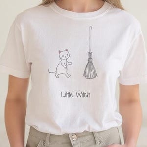 Magic Stroll Cat Unisex Softstyle T-Shirt, Cute Witch Cat Shirt with Broom, Halloween Tee, Cat Lover Gift, Magical Cat Shirt, Witchy Cat Top