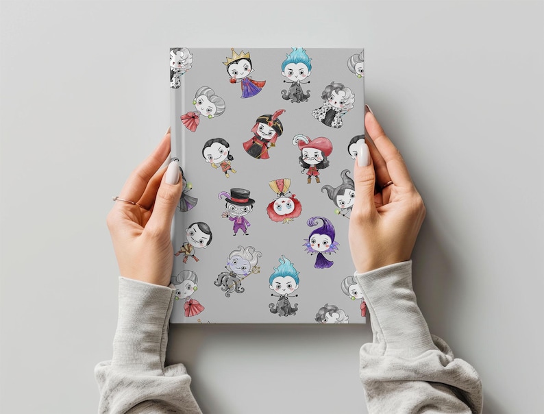 May include: A gray notebook featuring cartoon illustrations of various characters in colorful outfits. The notebook is held by hands with a light gray background.