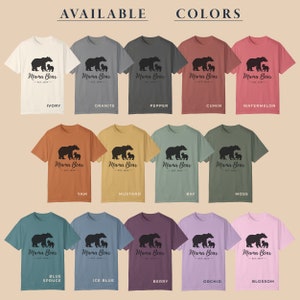 A chart of 15 different t-shirt colors with the words 'Available Colors' at the top. Each color has a t-shirt with a black graphic of a mama bear and two cubs with the text 'Mama Bear Est. 2024' below the graphic. The colors are: Ivory, Granite, Pepper, Cumin, Watermelon, Yam, Mustard, Bay, Moss, Blue Spruce, Ice Blue, Berry, Orchid, and Blossom.