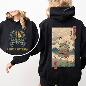 a woman wearing a black hoodie with an image of a skeleton on it