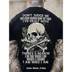 a man wearing a black shirt with a skull and crossbones on it