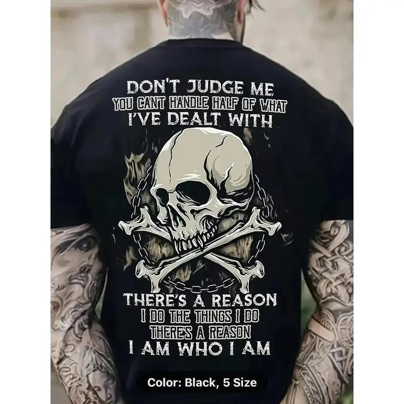 a man wearing a black shirt with a skull and crossbones on it