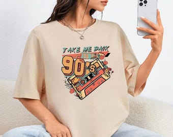May include: A beige t-shirt with a graphic print of a cassette tape and the text "Take Me Back to the 90's".
