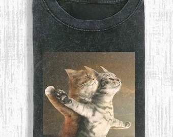 May include: Dark gray t-shirt featuring a vintage-style image of two cats embracing, reminiscent of a classic painting. The cats are a mix of orange and gray tabby, with their eyes closed. The text "Pepper Color" is at the bottom.