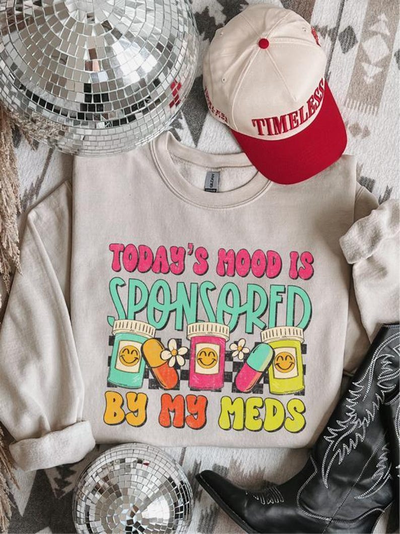 a hat, a pair of cowboy boots, and a sweatshirt on a bed
