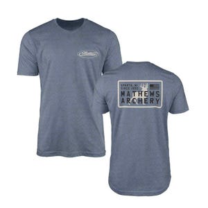 May include: Blue short-sleeved t-shirt with the Mathews Archery logo on the front and back. The front logo is an oval with the brand name. The back features a rectangular design with the text "SPARTA, MI SINCE 1992" and "MATHEWS ARCHERY".