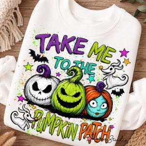 Może przedstawiać: Biała bluza z nadrukiem graficznym z napisem "TAKE ME TO THE PUMPKIN PATCH". Wzór przedstawia trzy dynie, dwa psy-duchy, nietoperze i kolorowe gwiazdy, ozdobione żywymi zielonymi, pomarańczowymi i fioletowymi rozpryskami farby.