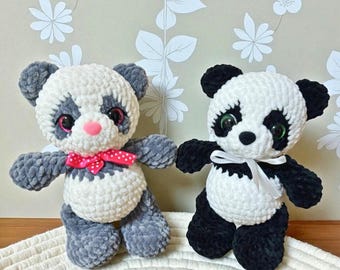 Può includere: Due orsetti panda all'uncinetto fatti a mano. Un panda ha braccia e gambe grigie, corpo bianco e un fiocco rosa. L'altro panda ha braccia e gambe nere, corpo bianco e un nastro bianco. Entrambi hanno facce in bianco e nero.