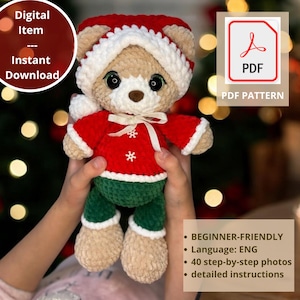 Op de afbeelding: Een handgemaakte gehaakte teddybeer met een rode en witte kerstmuts en trui, groene broek. De beer heeft een bruine neus en zwarte ogen. De afbeelding bevat de tekst "Digital Item - Instant Download" en "PDF PDF Pattern".