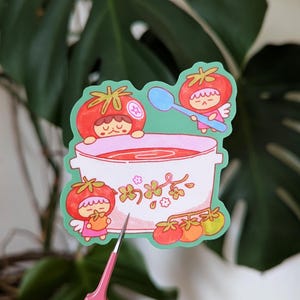 Cute illustrated sticker of tomato fairies making a big, warming bowl of tomato soup!