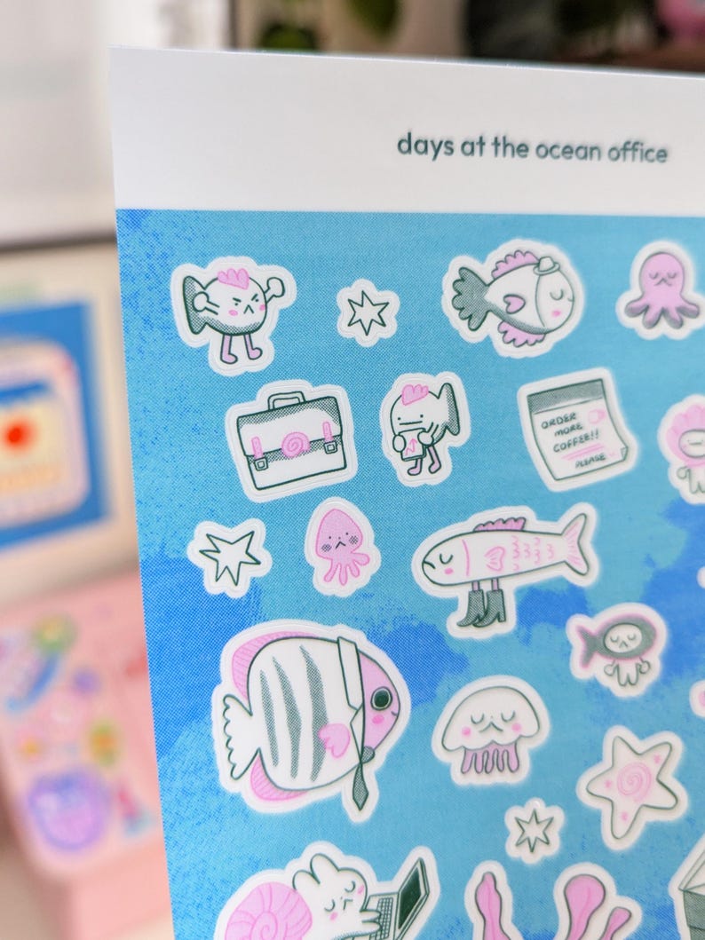 May include: A sheet of stickers with a blue background and various cartoon sea creatures. The stickers include fish, octopuses, and jellyfish, some wearing business attire. The text "days at the ocean office" is printed at the top.