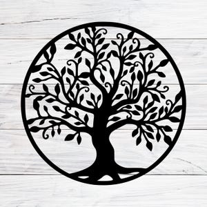 Könnte beinhalten: Ein schwarzes Design des Lebensbaums, kreisförmig. Der Baum hat einen dicken Stamm, Äste und viele Blätter, alles innerhalb eines kreisförmigen Rahmens. Das Design befindet sich auf einem weißen Holzhintergrund.