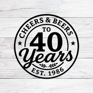 May include: A black and white circular design with the text "CHEERS & BEERS TO 40 Years EST. 1986". The design includes stars and a decorative leaf element, set against a white wood-grain background.