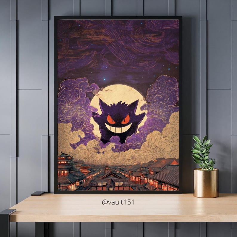 May include: Framed art print depicting a purple cartoon character with a wide grin against a full moon and cloudy sky. The artwork has a Japanese aesthetic, with a cityscape below. The print is displayed on a wooden surface.