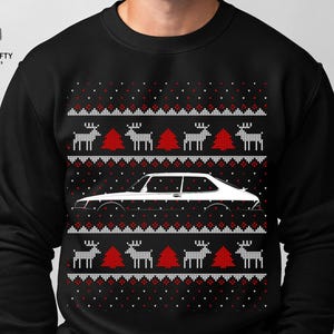 May include: Black sweatshirt with a white car graphic and a festive pattern of reindeer and Christmas trees in red and white. The Unicrafty Designs logo is in the upper left corner.
