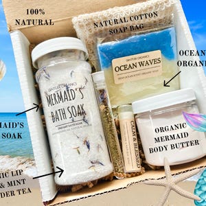 以下が含まれることがあります： 人魚をテーマにしたバス＆ボディ製品のギフトボックス。 Mermaid's Bath Soakの瓶、Ocean Wavesオーガニックソープ、オーガニック人魚ボディバター、リップバーム、ラベンダーティーが含まれています。ボックスには「100％ナチュラル」と記載されています。