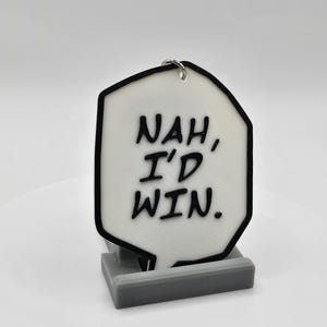 May include: White speech bubble keychain with black outline and text that reads "NAH, I'D WIN."