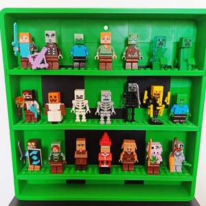 May include: A green plastic display shelf with three tiers, holding a collection of twenty Minecraft-themed minifigures. The figures include various characters, skeletons, zombies, and creatures, each standing on the integrated green brick base.