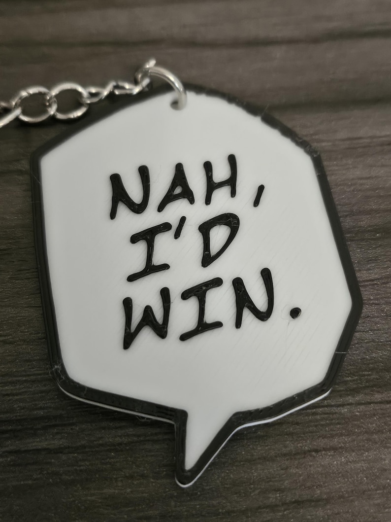 May include: White keychain with a black outline in the shape of a speech bubble. The text inside the bubble reads "NAH, I'D WIN."