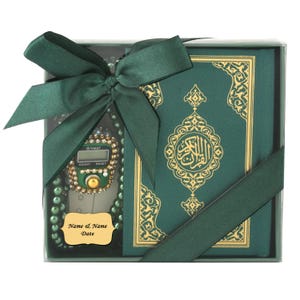 May include: A boxed gift set containing a green Quran with gold detailing, a digital prayer bead counter, and a string of green beads. The set is tied with a dark green satin ribbon. A small gold name tag is also included.