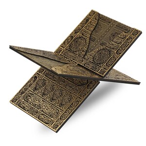 May include: A decorative wooden book stand with intricate gold-colored patterns and calligraphy on a black background. The stand is open, displaying multiple panels. The design features geometric shapes and ornate details, creating a sophisticated aesthetic.