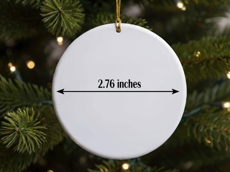 A white ornament with a measurement line on it, hanging on a Christmas tree.
