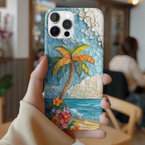 May include: A blue and white phone case featuring a tropical beach scene with a palm tree, ocean waves, and colorful flowers. The case has a mosaic-like design and a camera cutout.