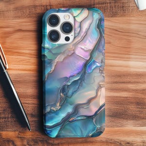 May include: A phone case with a blue, purple, and pink iridescent marble pattern. The case has a cutout for the camera lens.
