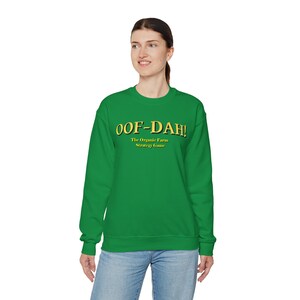 May include: A green sweatshirt with the text "OOF-DAH! The Organic Farm Strategy Game" in yellow.