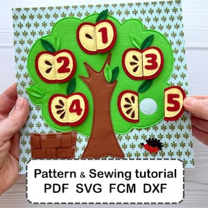 May include: A felt craft project featuring a green tree with a brown trunk on a patterned background. Five red apple halves with numbers one through five are attached, with a brown basket and a small hedgehog. Text reads: Pattern & Sewing tutorial PDF SVG FCM DXF.