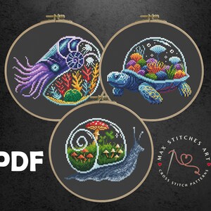 Peut inclure: Trois motifs de point de croix dans des cerceaux à broder. Les motifs présentent un nautile, une tortue de mer et un escargot, chacun avec des scènes colorées et détaillées. Le mot "PDF" est visible à gauche, et le texte "MAX STITCHES ART" est à droite.