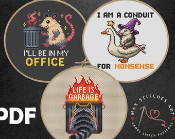 May include: Three cross-stitch patterns in embroidery hoops. One features a possum by a trash can with the text "I'LL BE IN MY OFFICE." Another shows a possum riding a goose with the text "I AM A CONDUIT FOR NONSENSE." The third has a raccoon and the text "LIFE IS GARBAGE."