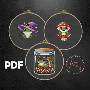 May include: Three cross stitch patterns featuring a frog wearing a witch hat, a frog sitting on a mushroom, and a frog in a jar with mushrooms. The patterns are printed on black fabric and are framed in wooden hoops. The text "PDF" is printed in white on a black background. The text "Max Stitches Art Cross Stitch Patterns" is printed in white on a red heart.