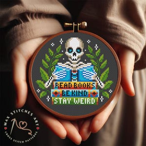 Peut inclure: Un motif de point de croix représentant un squelette tenant une pile de livres avec le texte "Read Books Be Kind Stay Weird".